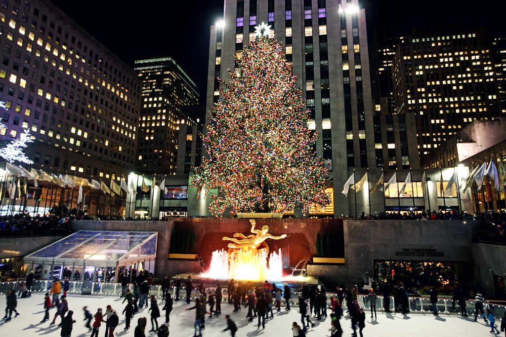 New York City, NY, USA – December 28, 2014: Rockefeller Center Christmas Tree lit up for the holidays. People skating in the Rockefeller Center Ice Rink.