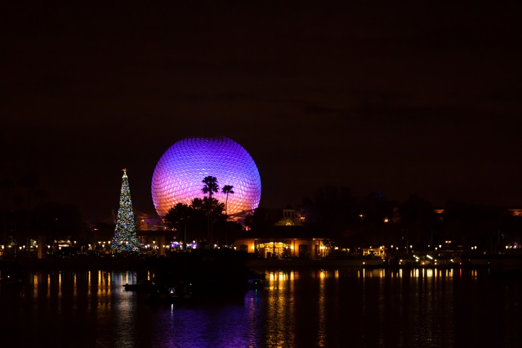Orlando, Fl, USA- December 9, 2015:  Spaceship Earth illuminated at night with large Christmas tree viewed from the world showcase in Disney World's Epcot amusement park.
