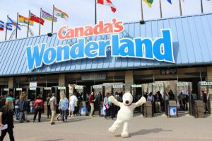 Imagem da fachada do Canada's Wonderland. A imagem aparece a frente do parque com catracas e o nome "Canada's" escrito na cor vermelha e "Wonderland" em baixo na cor azul. Embaixo tem um boneco do Snoopy, personagem do desenho animado com os braços abertos olhando para frente.