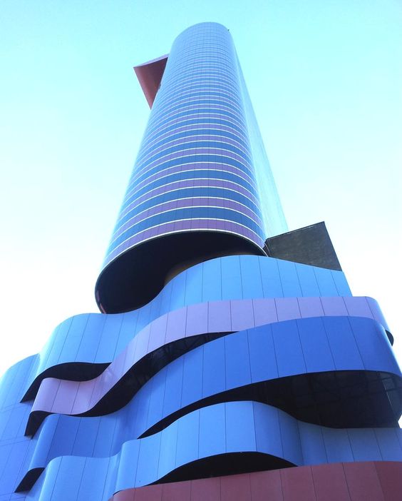Descrição da imagem: a foto mostra as divertidas curvas do prédio do Instituto Tomie Ohtake. O arranha-céu tem um misto de cores que vão do azul ao roxo.