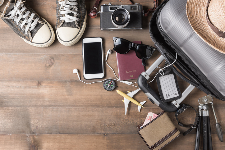 Objetos espalhados no chão para organizar bagagem para viagem ao exterior